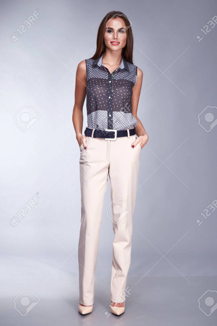 美おしゃれな女性シルクのブラウスとパンツ ファッション スタイル見てビジネス服会議と長いブルネットの髪 日焼け肌メイク パーティーでセクシーな女性のカジュアルな手にポケットを保持します の写真素材 画像素材 Image