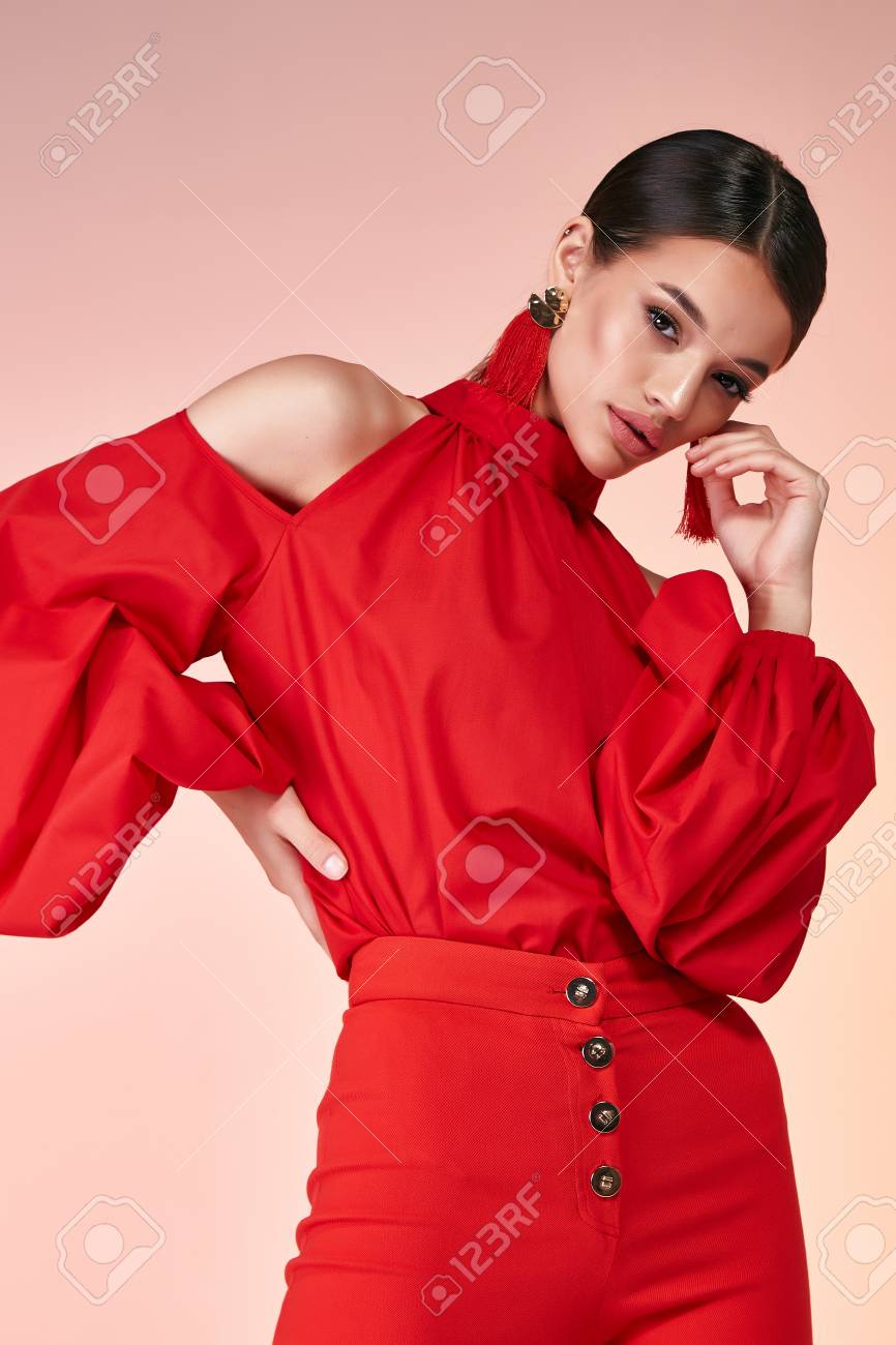 Pretty beautiful elegance woman fashion model glamor pose wear red color trousers silk blouse clothes for party summer collection makeup hair style brunette success accessory bag jewelry studio. - 106827302 Pretty beautiful elegance woman fashion model glamor pose wear red color trousers silk blouse clothes for party summer collection makeup hair style brunette success accessory bag jewelry studio. - 106827302