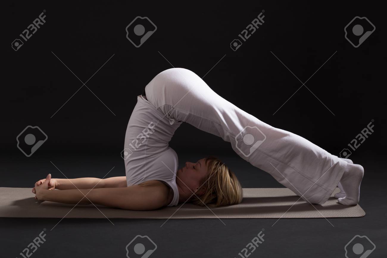 鋤のポーズ Halasana 黒背景の室内ヨガを行使する女性 の写真素材 画像素材 Image