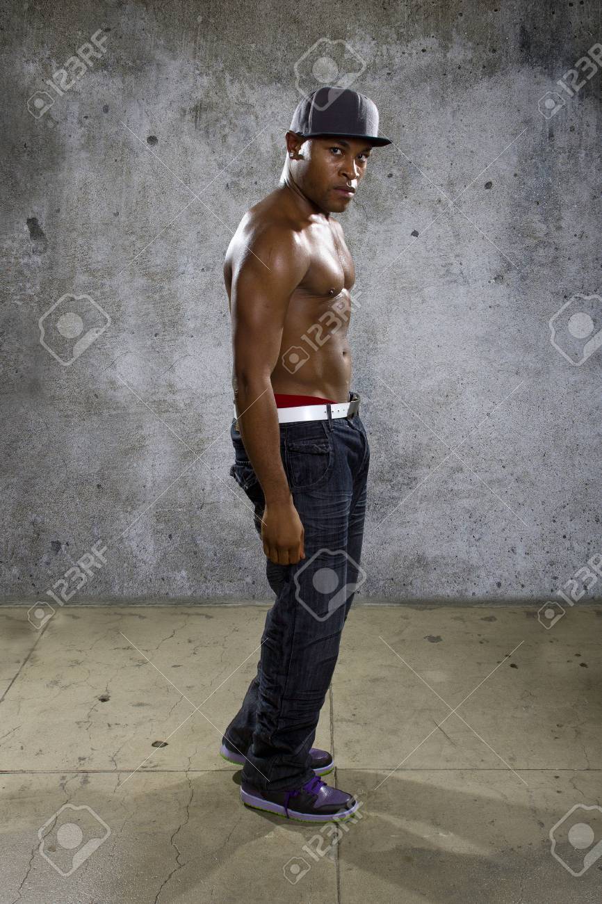 Banque d\u0027images , Torse nu musclé homme noir portant des vêtements de style urbain de hip hop sur fond de béton