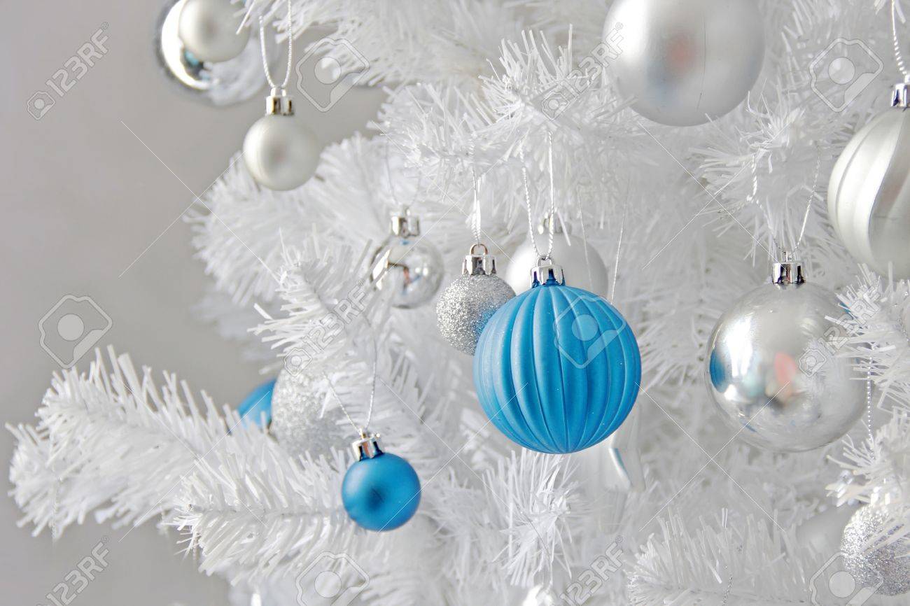 Boule De Noël Bleu Et Argent Accrochée à Un Arbre De Noël Blanc