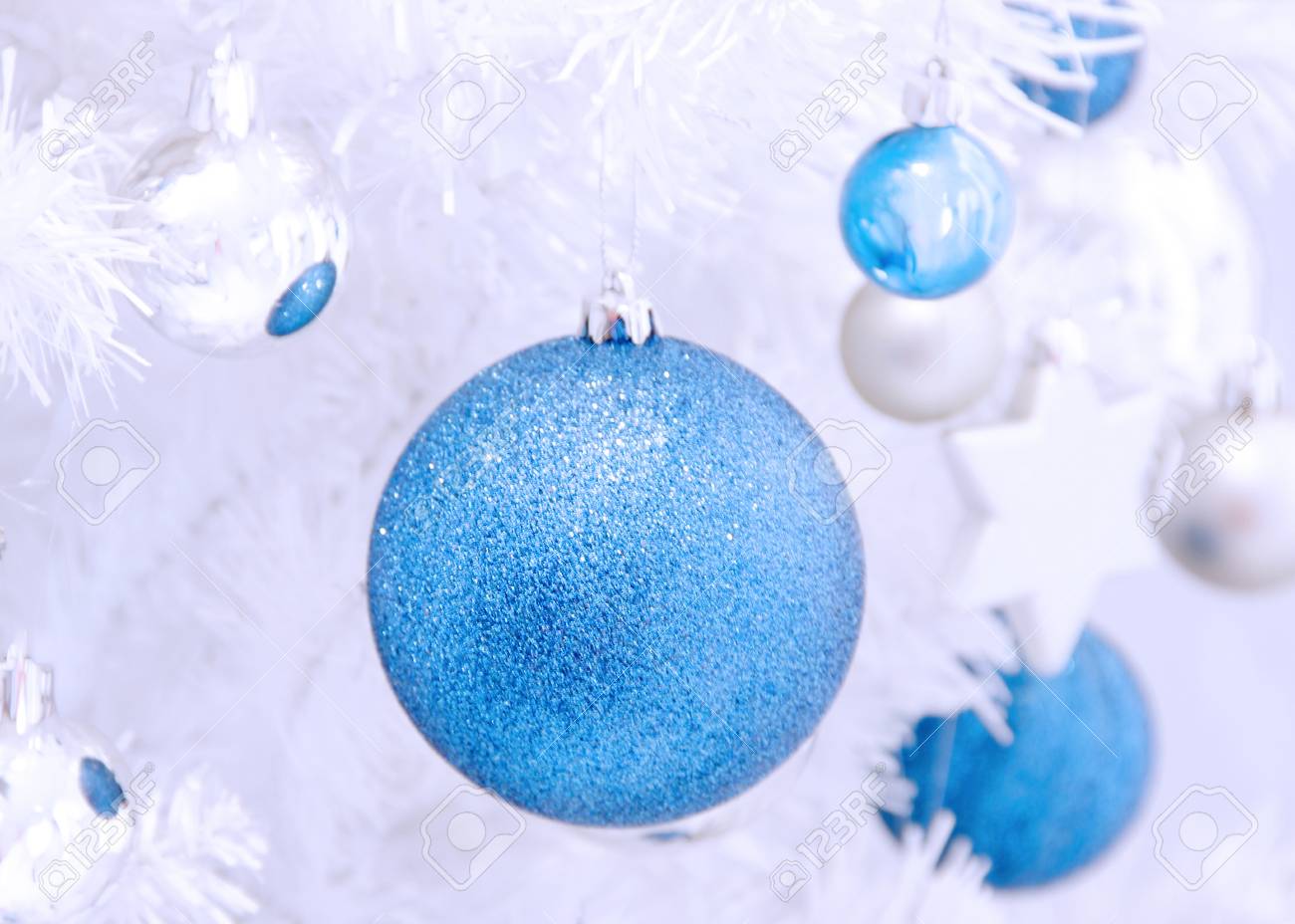 Boule De Noël Bleu Et Argent Accrochée à Un Arbre De Noël Blanc