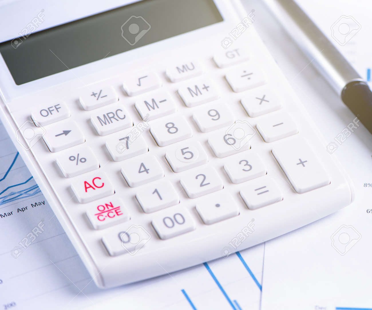 White calculator and report with chart and graph, concept of annual financial profit overview, banking and investment, copy space, macro, close up - 125326911 White calculator and report with chart and graph, concept of annual financial profit overview, banking and investment, copy space, macro, close up - 125326911