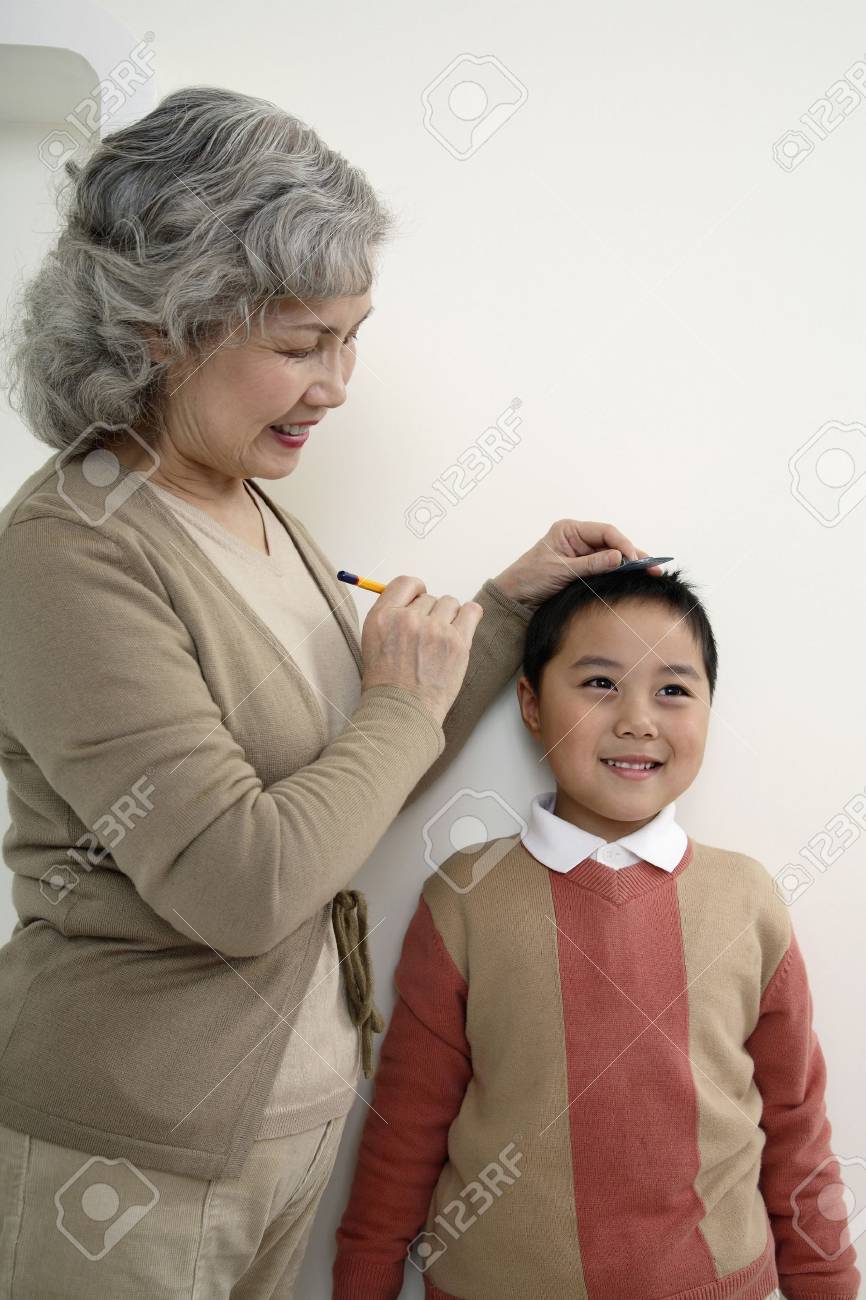 Superior De La Mujer Marca La Altura De Nino En La Pared Fotos