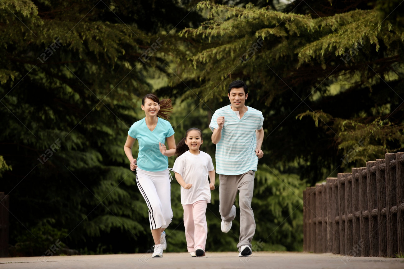 Girl and parents running in the park - 26203378 Girl and parents running in the park - 26203378