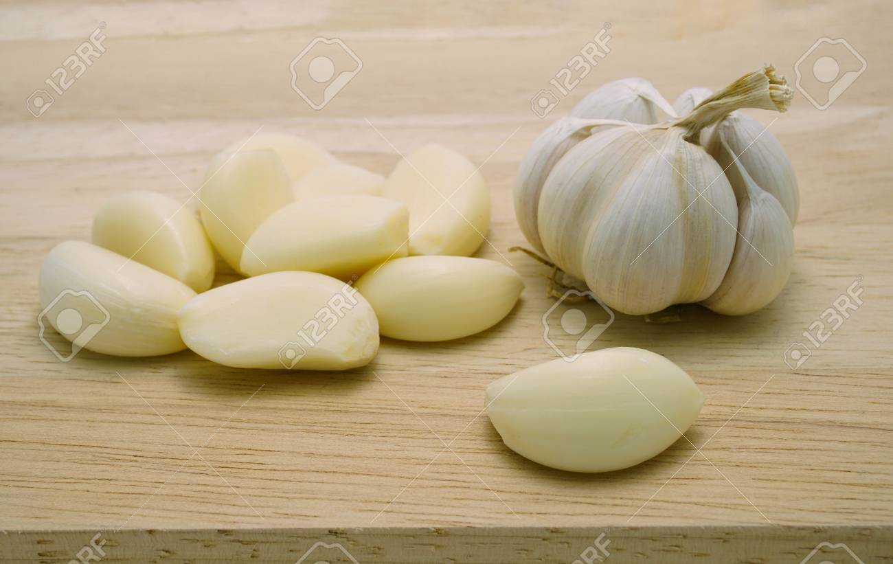 Ail Entier Et Tas De Gousses D Ail Pelees Au Bord D Une Table En Bois Une Sorte D Ingredient De Cuisine Plantes Medicinales Et Aliments Sains Lies A La Pression Arterielle Aux Antibiotiques Etc