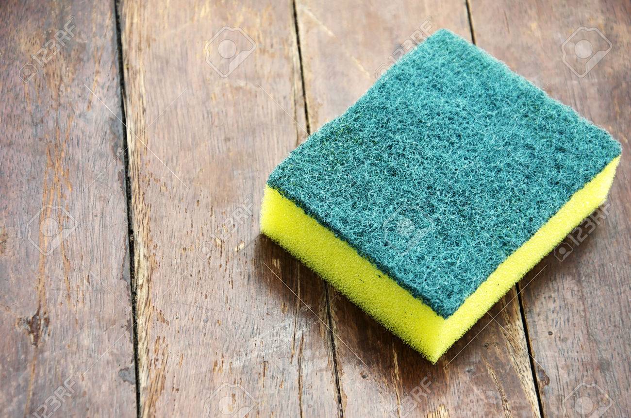 Dishwashing sponge with a wooden floor in the background. - 51332304 Dishwashing sponge with a wooden floor in the background. - 51332304
