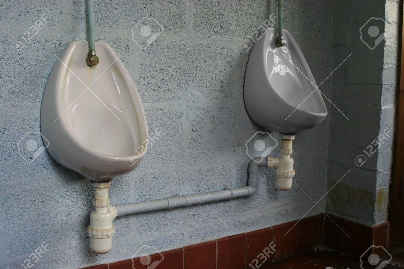 Dos Urinarios De Porcelana Azul En La Pared En Los Hombres De Bano
