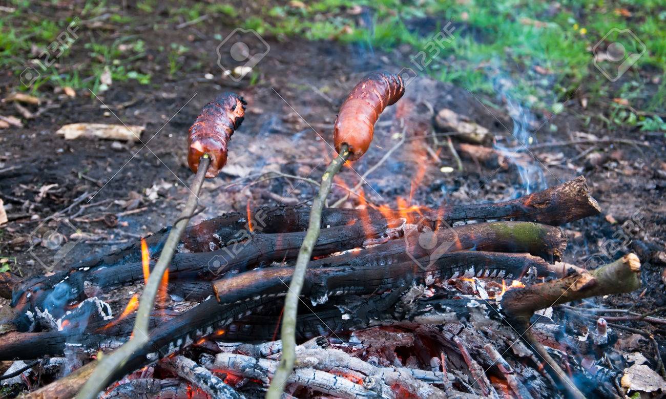 sausages roasting over fire flames stock photo picture and royalty