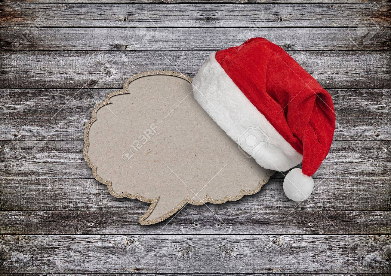 blank recycled paper speech bubble with santa hat on wood background