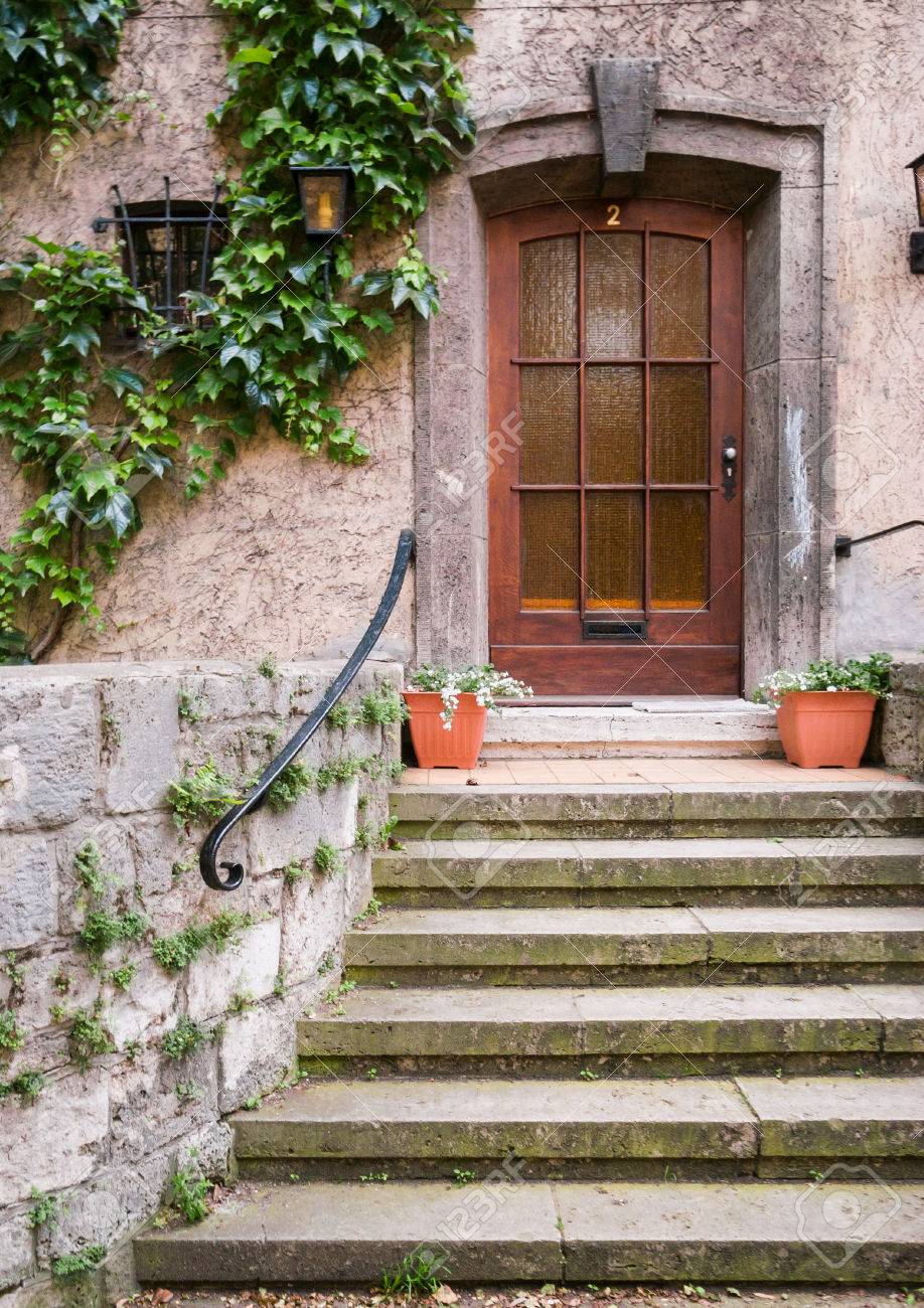 Holz Haustur Mit Tur Wildem Wein Und Blumentopfe Vor Lizenzfreie