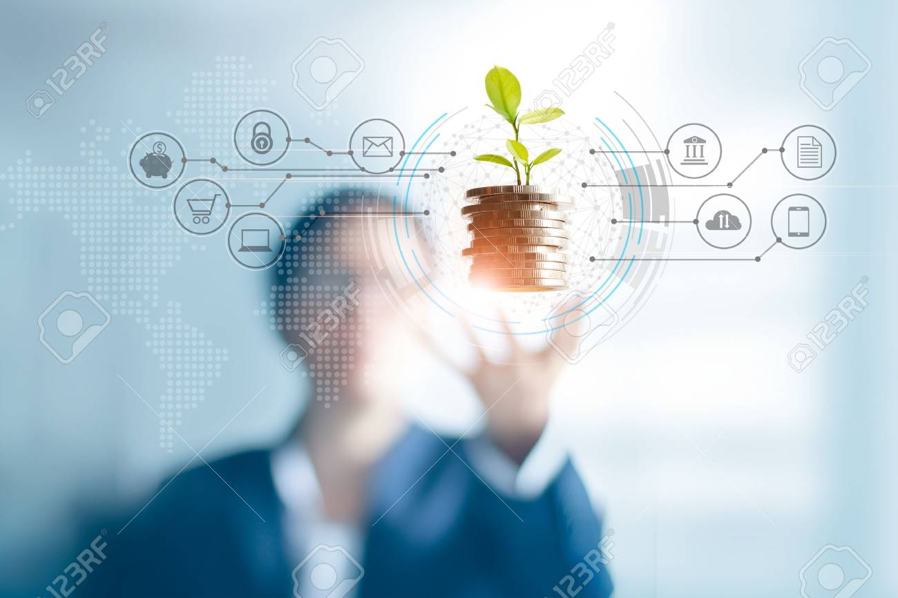 Businessman holding a tree sprout growing on coins, abstract growth investing. Finance and icon customer, banking network connection on interface, digital marketing, investment growth and business technology concept - 126271250 Businessman holding a tree sprout growing on coins, abstract growth investing. Finance and icon customer, banking network connection on interface, digital marketing, investment growth and business technology concept - 126271250