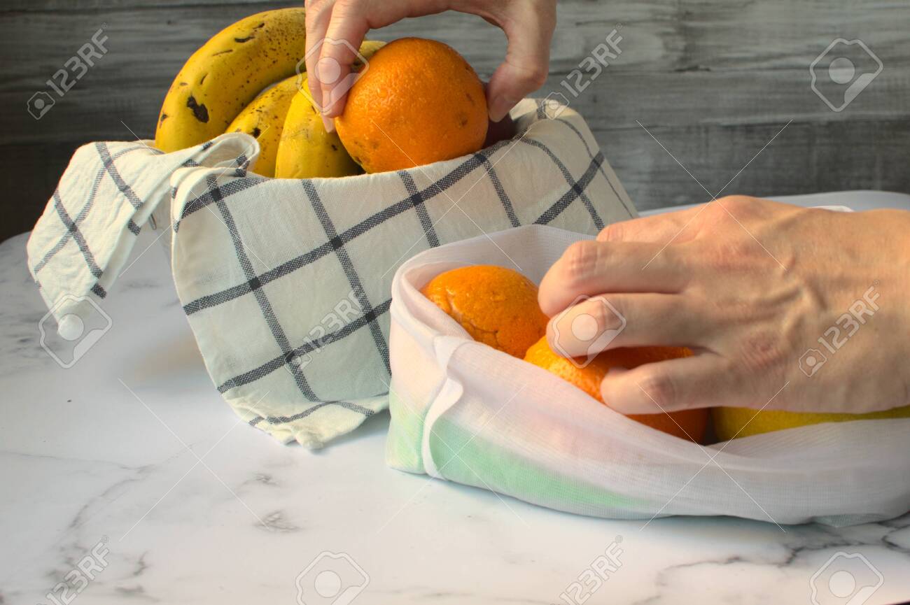 Woman Taking Orange Out Of A White Cloth Bag And Leaving Them In A Fruit Bowl With Other Fruits の写真素材 画像素材 Image