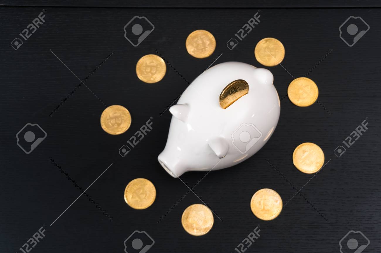 Porquinho Branco Com Uma Moeda De Bitcoin De Ouro Novo Dinheiro Virtual Em  Um Fundo De Madeira Colorido Foto Royalty Free, Gravuras, Imagens e Banco  de fotografias. Image 97311786