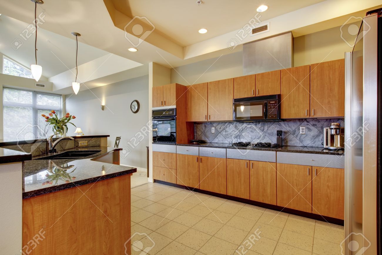Große moderne holz küche mit wohnzimmer und hohen decken und elfenbein wänden lizenzfreie bilder
