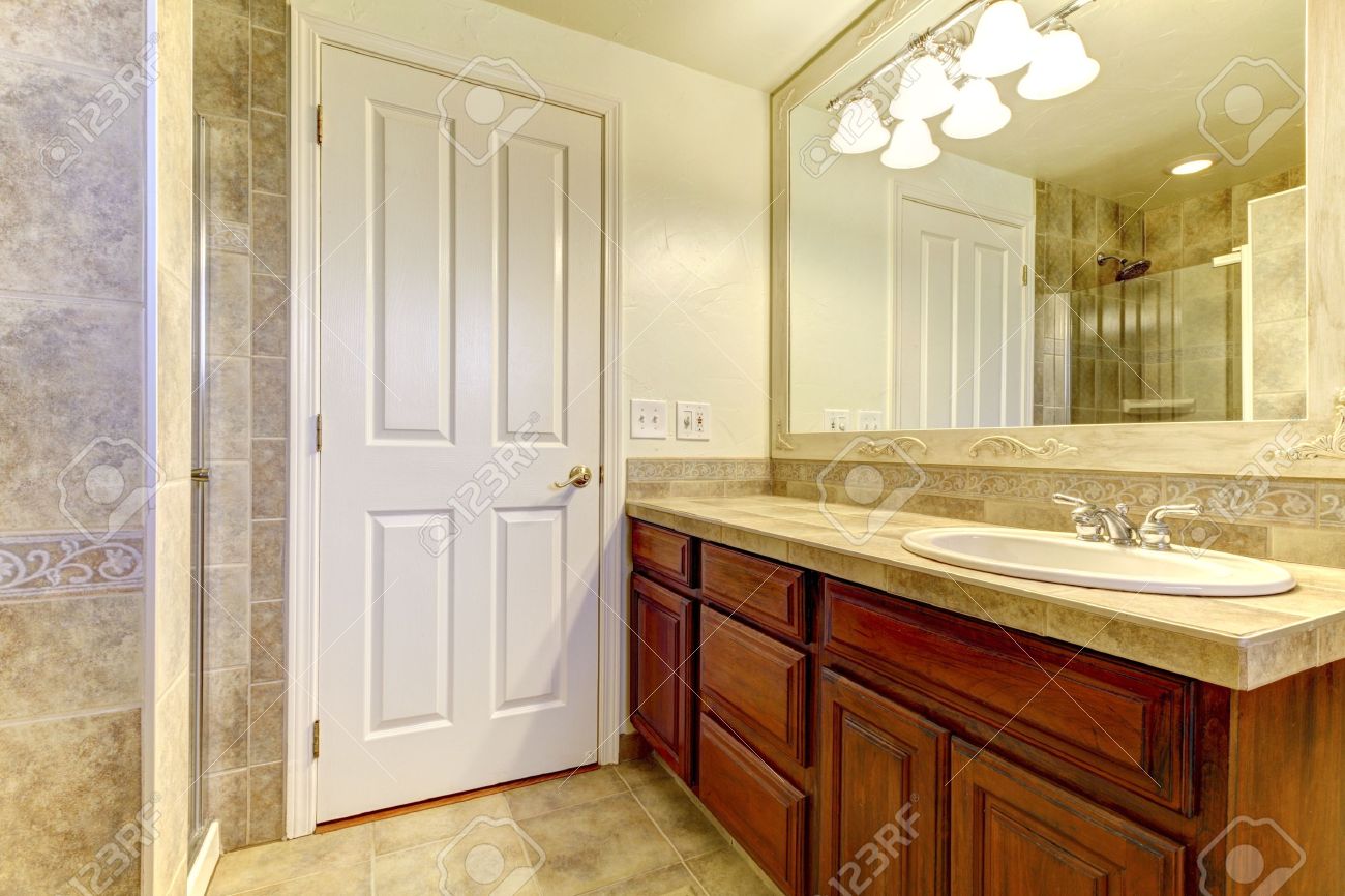 Bagno con piastrelle in pietra e doccia in vetro con armadi in ...