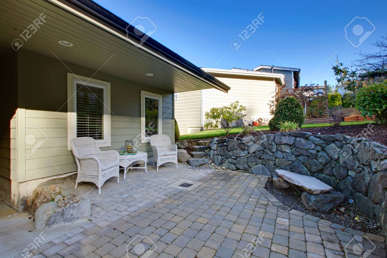 籐パティオ テーブル セット 石造りのベンチ 石階段は小さな庭につながる素晴らしい投石ポーチ の写真素材 画像素材 Image
