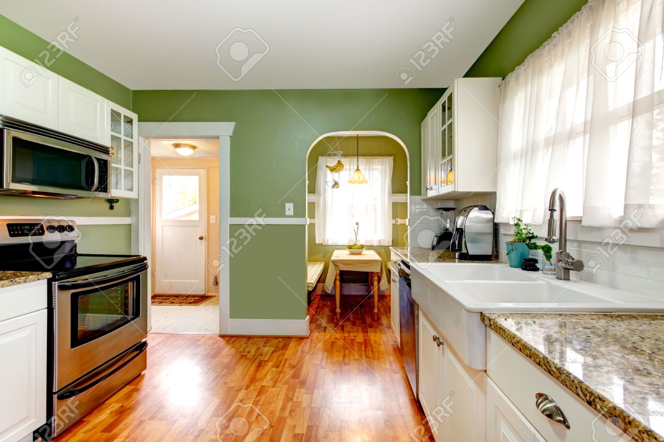 Bright Kitchen Room With Green Wall And Hardwood Floor. Kitchen With White  Cabinets And Steel Appliances. Open To Dining Area Stock Photo, Picture and  Royalty Free Image. Image 26095017., image size:1300x866