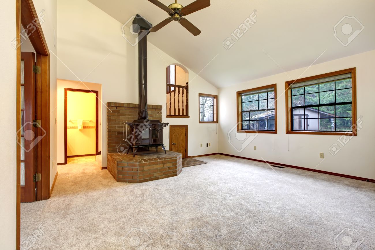 Bauernhaus wohnzimmer mit gewölbter decke und teppichboden brick basis mit einem antiken ofen auf sie