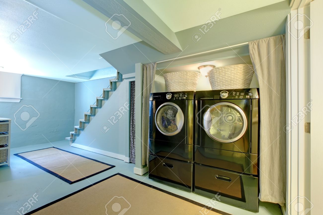 Bleu buanderie au sous-sol avec wache noire et sèche-linge. Bleu buanderie au sous-sol avec wache noire et sèche-linge.