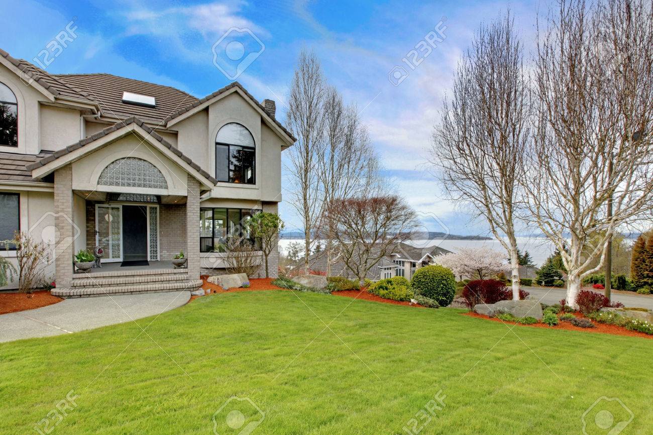 Luxury House Exterior luxury house exterior with flower beds and lawn. water view stock Luxury House Exterior luxury house exterior with flower beds and lawn. water view stock