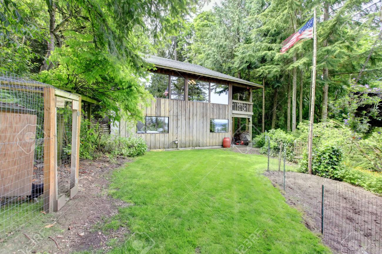 裏庭で田舎の家 芝生とフェンスで囲まれた庭のベッドのビュー の写真素材 画像素材 Image