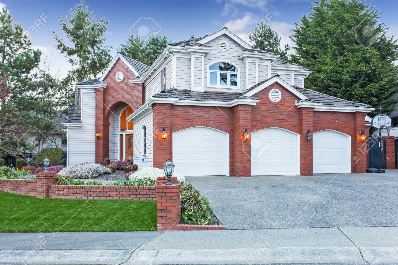 luxury house exterior with red brick wall trim with three car garage and driveway stock - Luxury Homes Exterior Brick luxury house exterior with red brick wall trim with three car garage and driveway stock - Luxury Homes Exterior Brick
