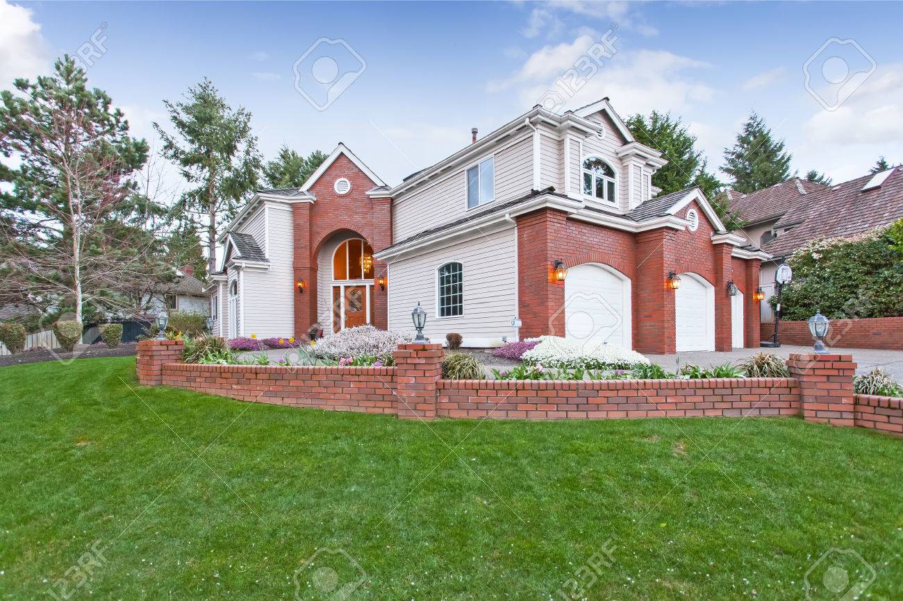 luxury house exterior with red brick wall trim with three car garage and driveway - Luxury House Exterior luxury house exterior with red brick wall trim with three car garage and driveway - Luxury House Exterior