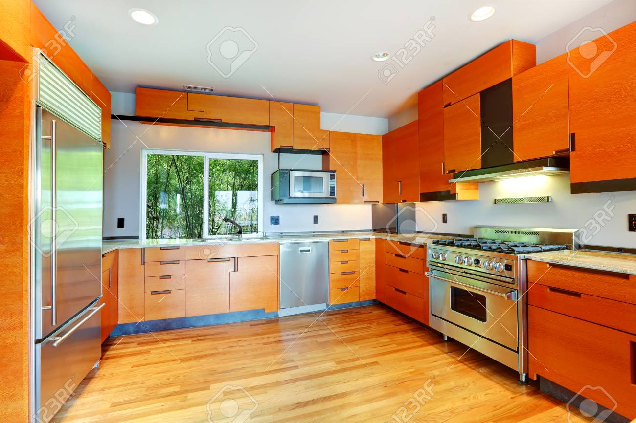 Moderna Sala De Cocina Con Gabinetes De Color Naranja Y Electrodomésticos De Acero