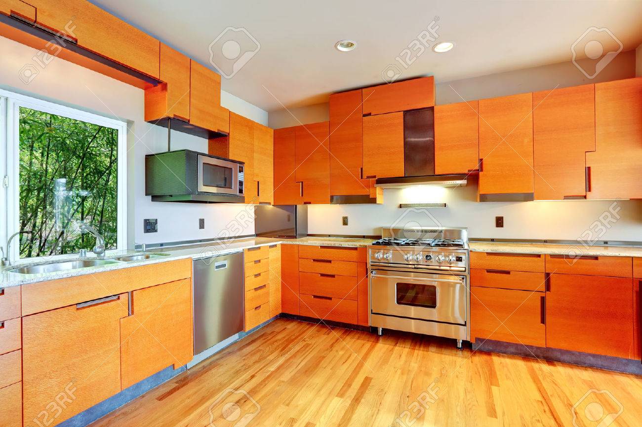 Moderna Sala De Cocina Con Gabinetes De Color Naranja Y Electrodomésticos De Acero