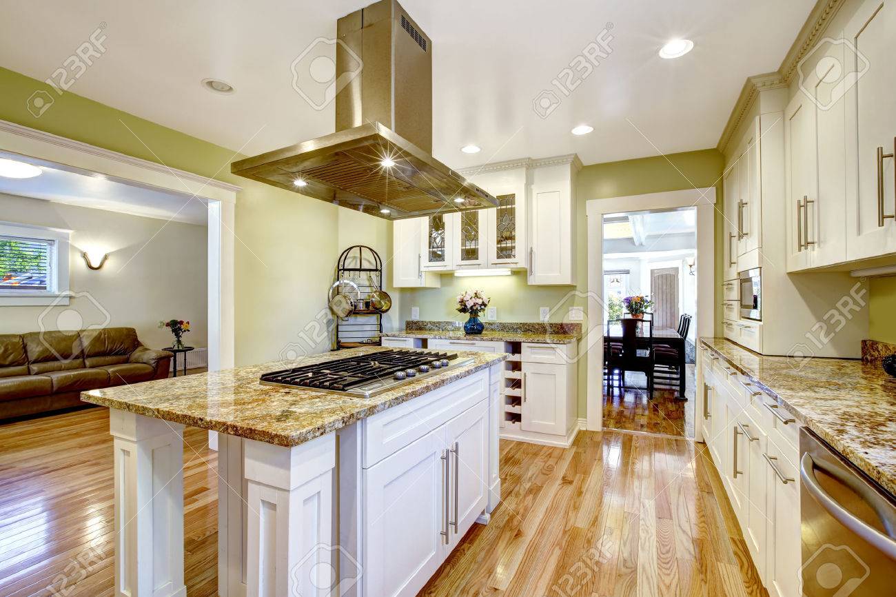 Diseño De Cocina Moderna Y Práctica. Mueble Blanco Con Encimera De Granito, Isla  De Cocina Con Una Función De Estufa Y Campana De Acero Fotos, Retratos,  Imágenes Y Fotografía De Archivo Libres