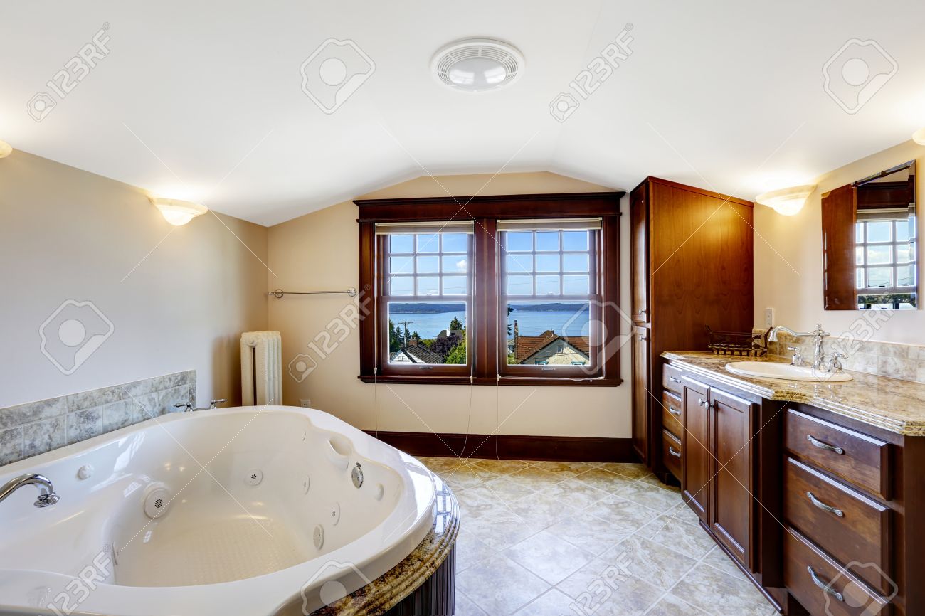 Bagno di lusso con idromassaggio, armadietto marrone e bianco ...