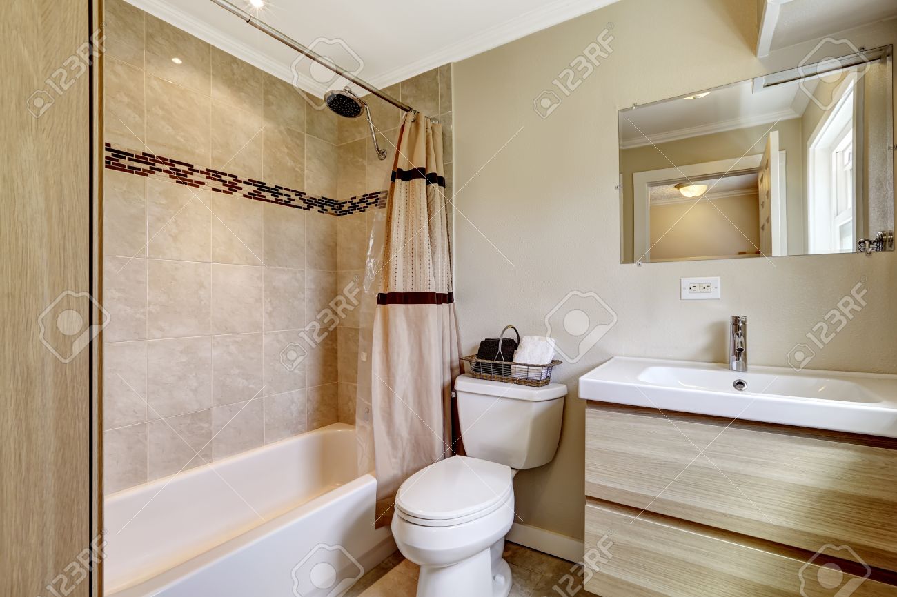 Salle de bains avec carreaux de faïence beige et pêche rideau. Cabinet moderne avec évier sur tout le dessus Salle de bains avec carreaux de faïence beige et pêche rideau. Cabinet moderne avec évier sur tout le dessus