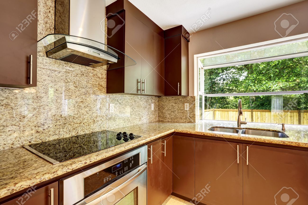 Camera moderna cucina con mobili marrone opaco, cime di granito ...