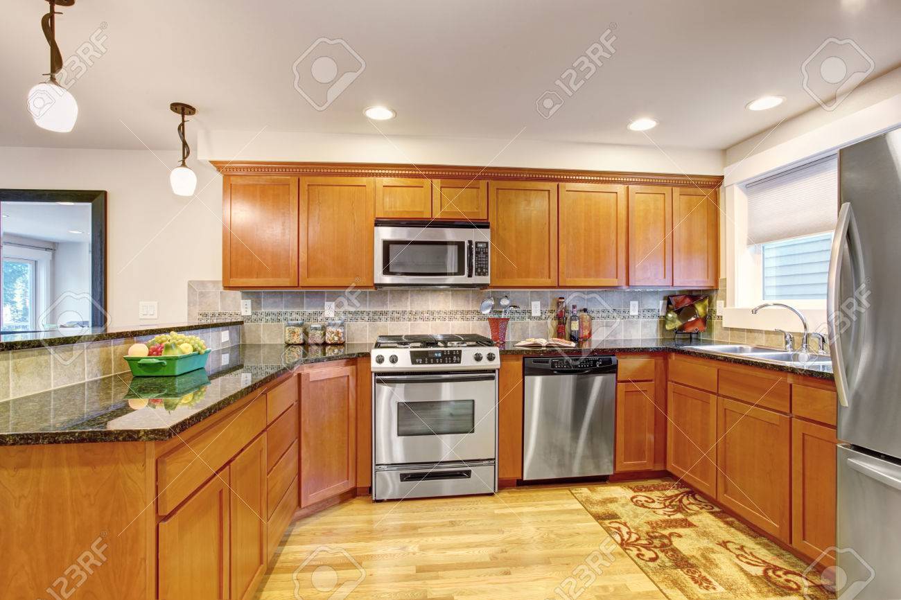 Maple Kitchen Cabinets With Steel Appliances And Granite Tops