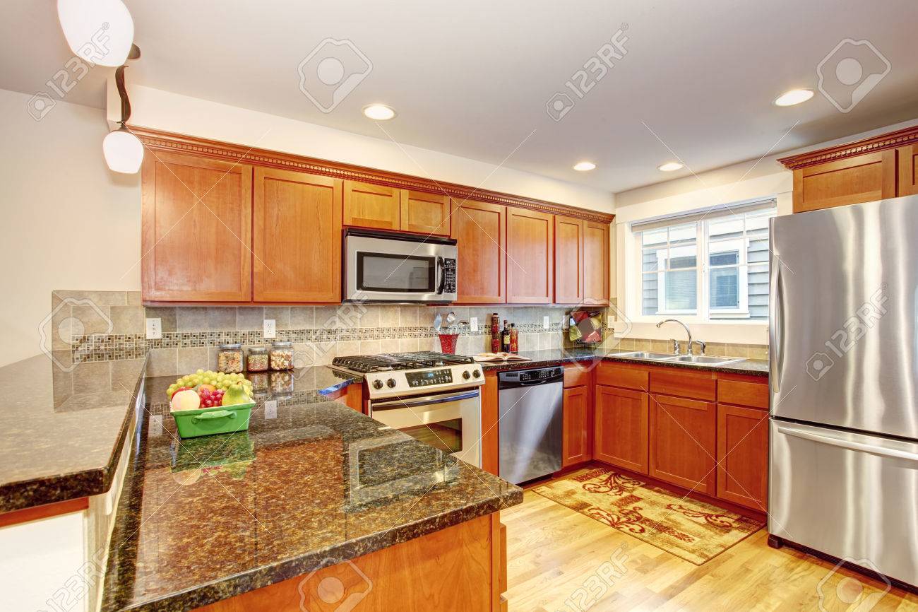 Maple Kitchen Cabinets With Steel Appliances And Granite Tops