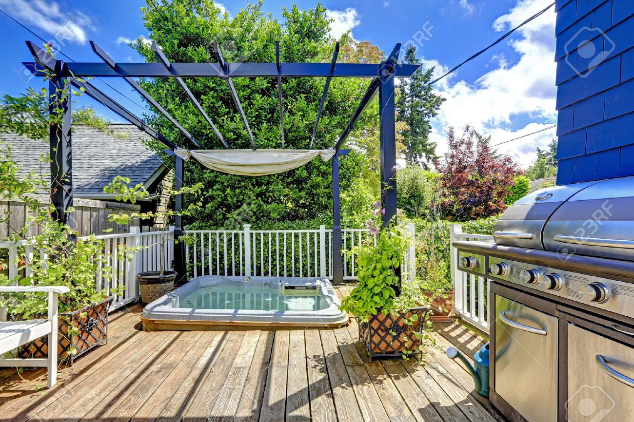 Walkout deck with jacuzzi and pergola. Patio area with barbecue - 34354302 Walkout deck with jacuzzi and pergola. Patio area with barbecue - 34354302