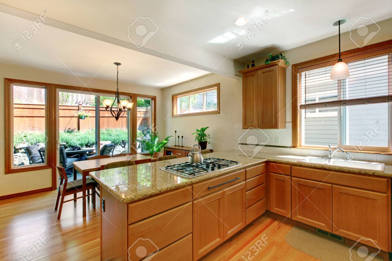 Sala De Cocina Marron Y Blanca Con Piso De Madera Armarios