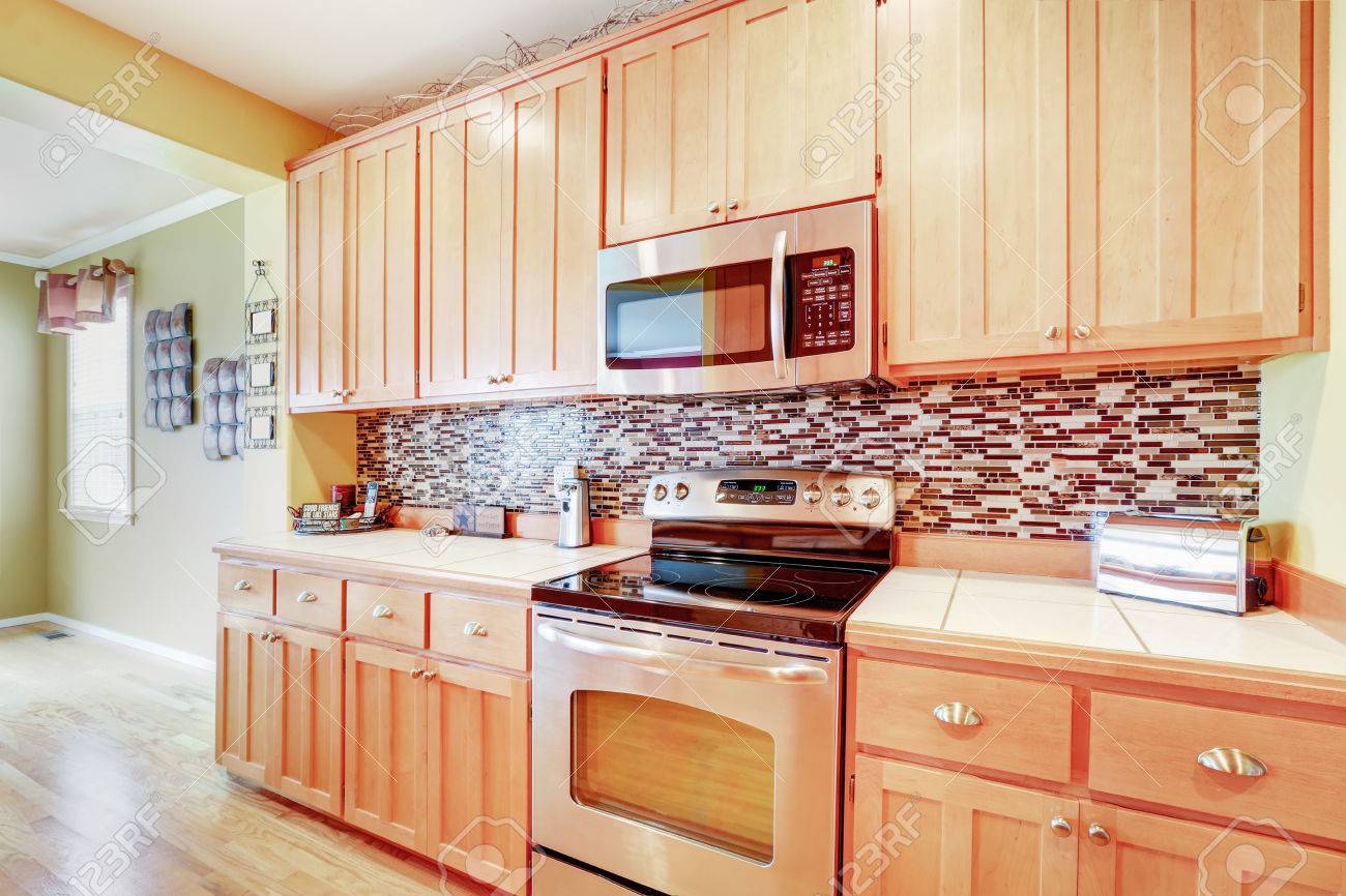 Light Wood Cabinets With Multicolored Backsplash And Modern Stainless Stock Photo Picture And Royalty Free Image Image 64698827