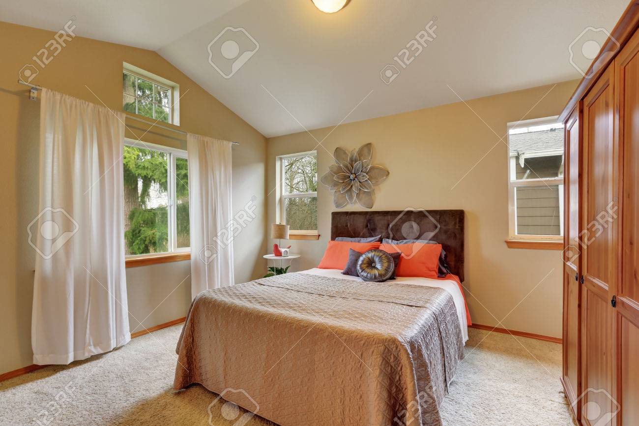 Upstairs Bedroom With Vaulted Ceiling And Beige Walls Bed With