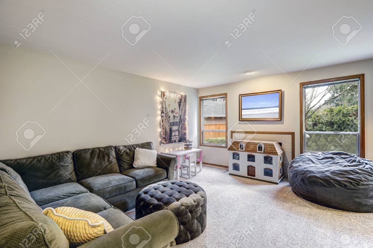 Neutral Wohnzimmer Innenraum Mit Grauen Ecksofa Mit Tufting-Ottomane ... Neutral Wohnzimmer Innenraum Mit Grauen Ecksofa Mit Tufting-Ottomane ...