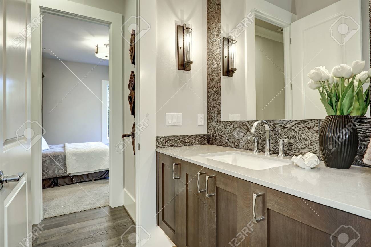 White And Brown Bathroom Boasts A Nook Filled With A Taupe Vanity - White And Brown Bathroom Boasts A Nook Filled With A Taupe Vanity
