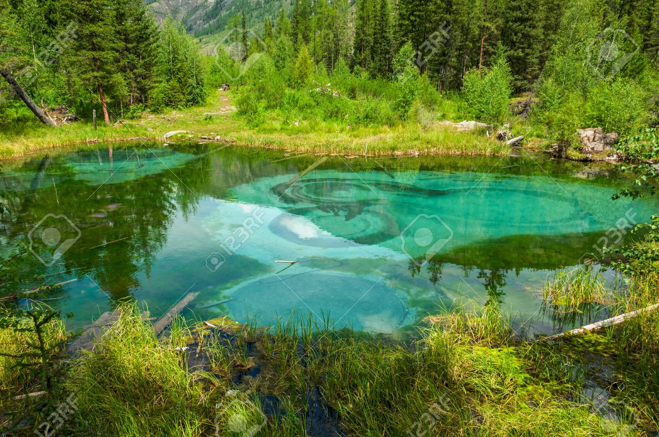 透明な青緑色の水と山の森の底に汚れが付いている美しい森間欠泉湖 の写真素材 画像素材 Image 34228763
