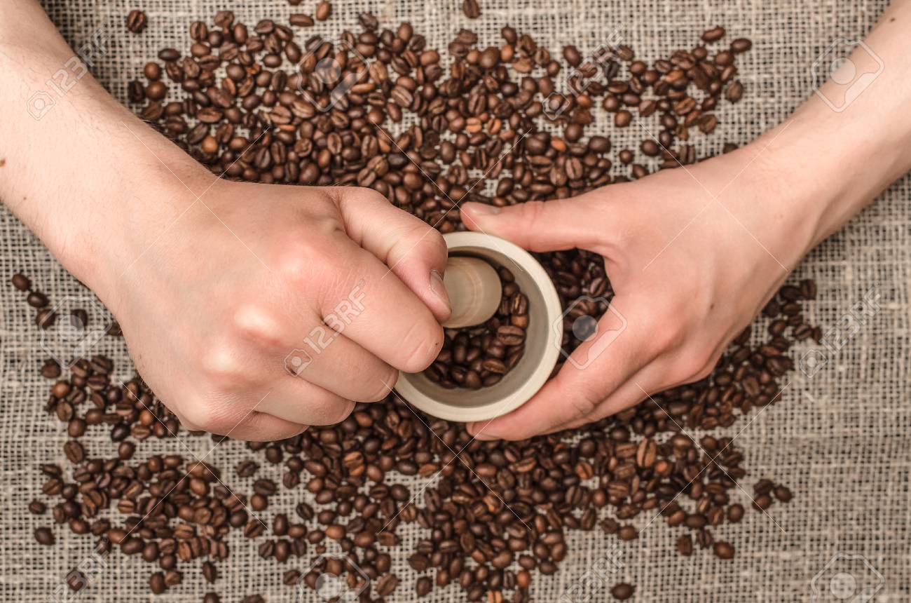 Man Hands Grinds Coffee Beans In The Wooden Mortar By Pestle In His Hands Stock Photo Picture And Royalty Free Image Image 102052242