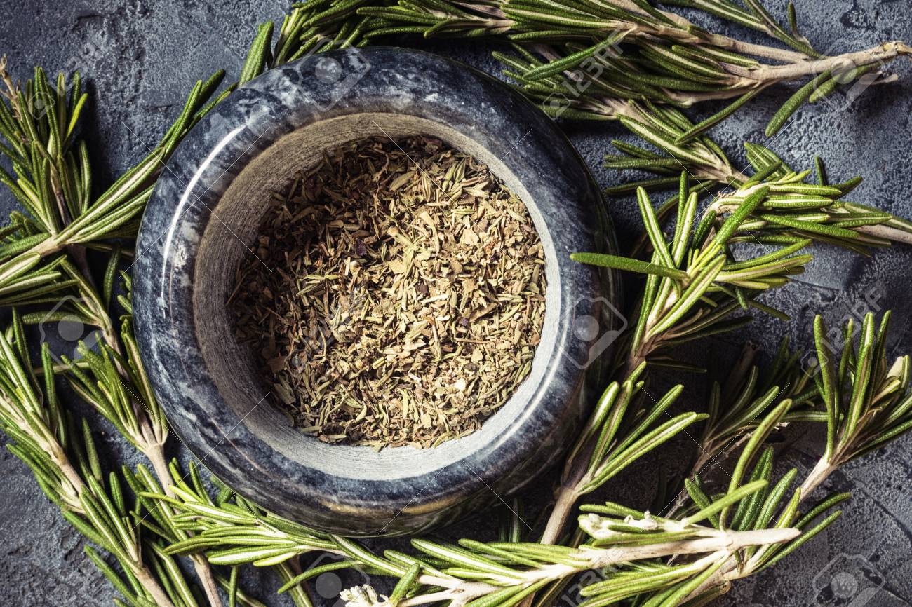Branch Bunch Fresh Rosemary And Dried Leaves Spice In Mortar Pounder Food Concept Grass Crop Spices Harvest Herbs For Medicine And Cooking On Gray Background Dark Key Low Key. Stock Photo, Picture