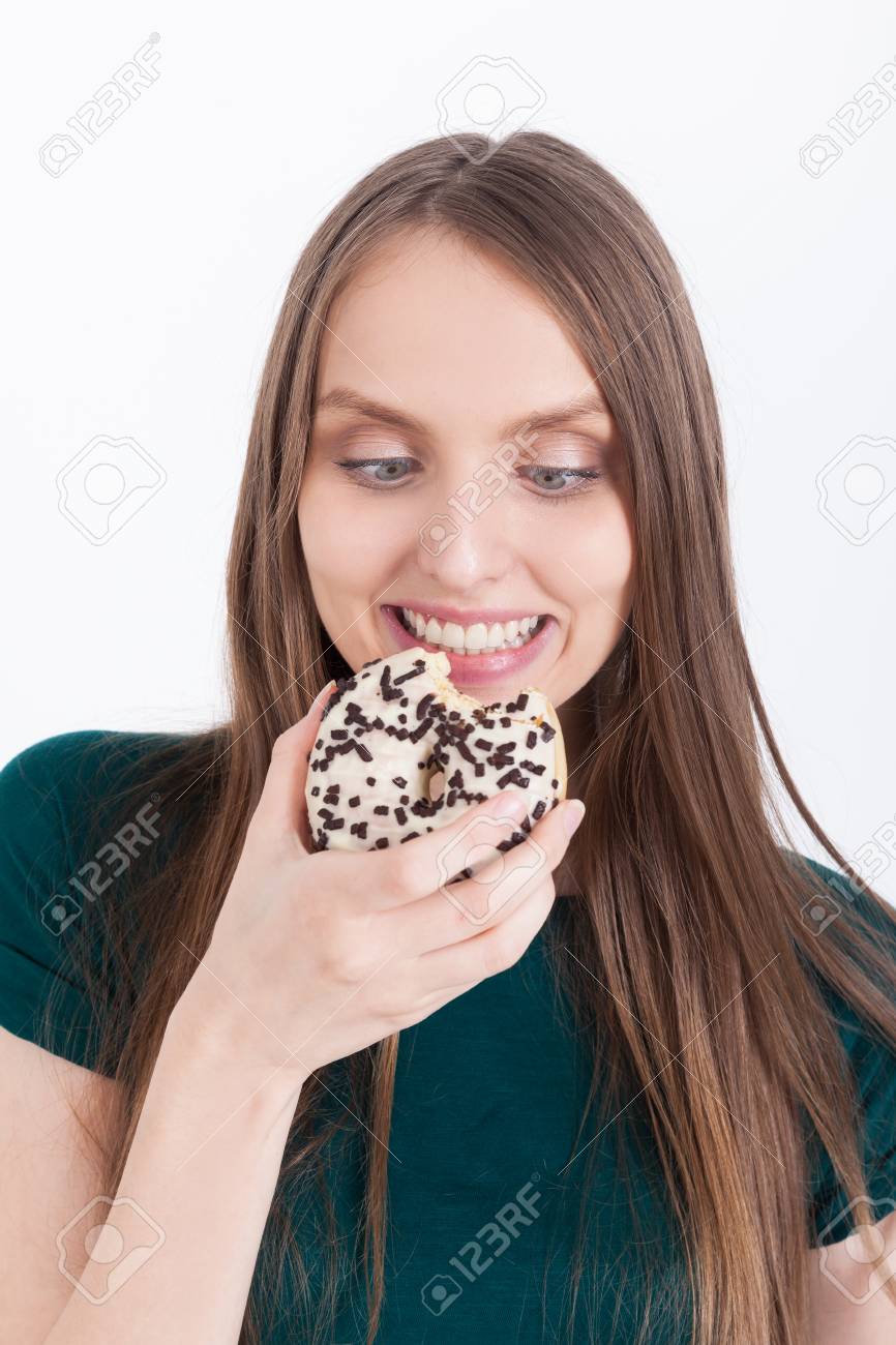 オオカミの食欲と緑の T シャツの女の子がドーナツを見て 無限の喜びとかみます 大食いの概念 の写真素材 画像素材 Image