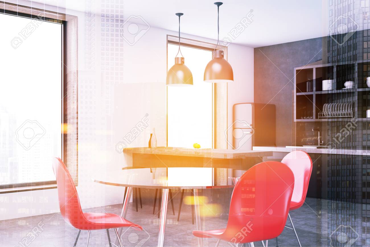 corner of a modern kitchen with a round talbe red chairs large