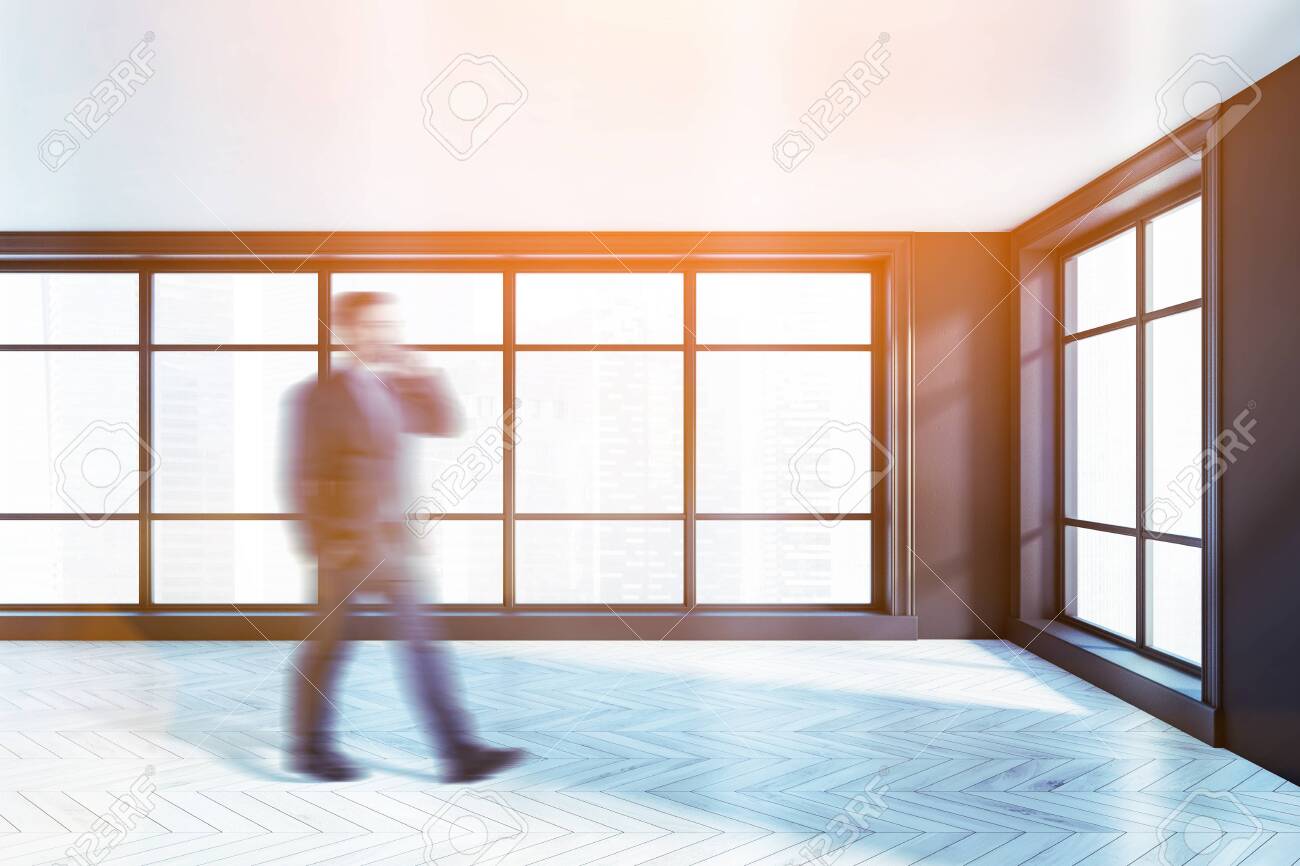 Blurry Young Businessman Walking In Luxury Empty Apartment With
