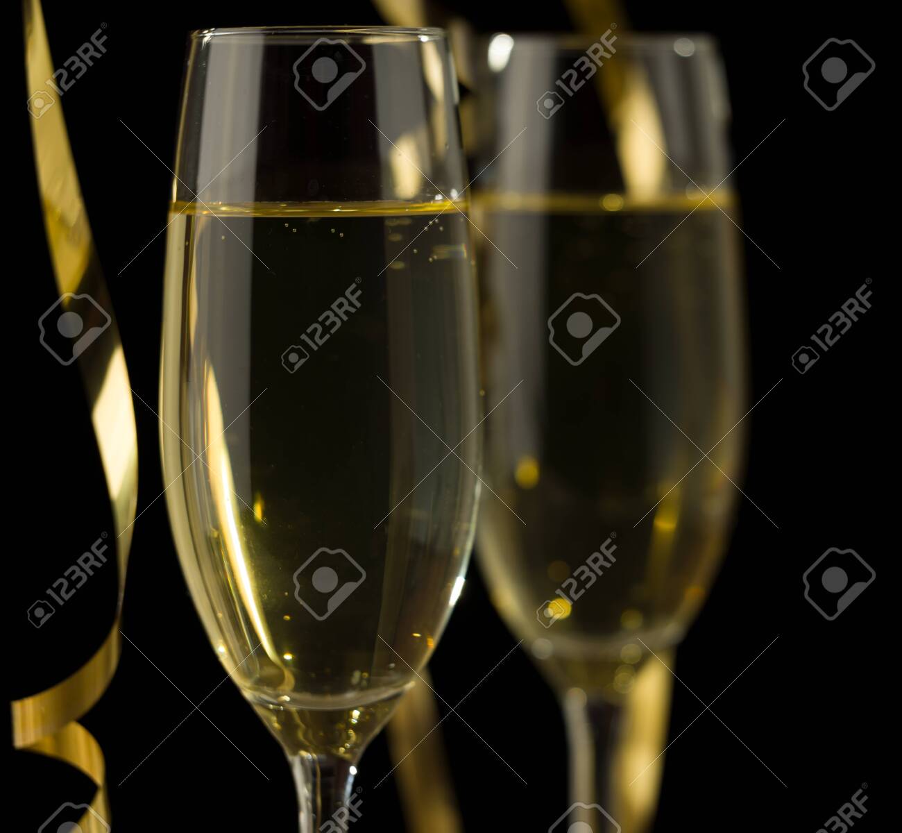 Two glasses of champagne in front of dark background - 137576570 Two glasses of champagne in front of dark background - 137576570