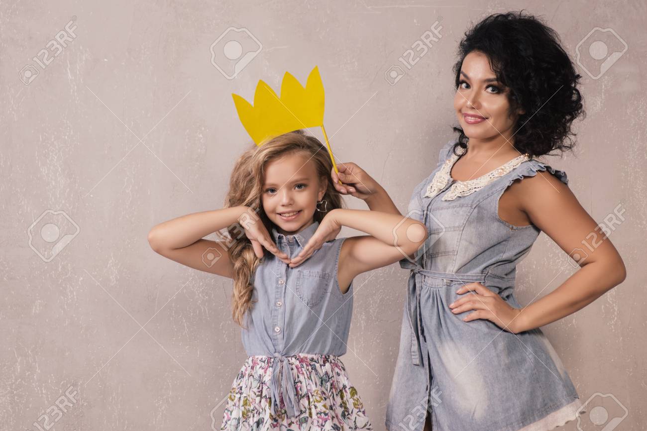 funny mother and her daughter girl with a paper accessories mom and